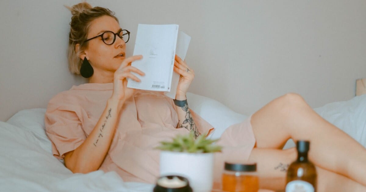 Person practicing a relaxing bedtime routine, like reading a book - Ambien Detox