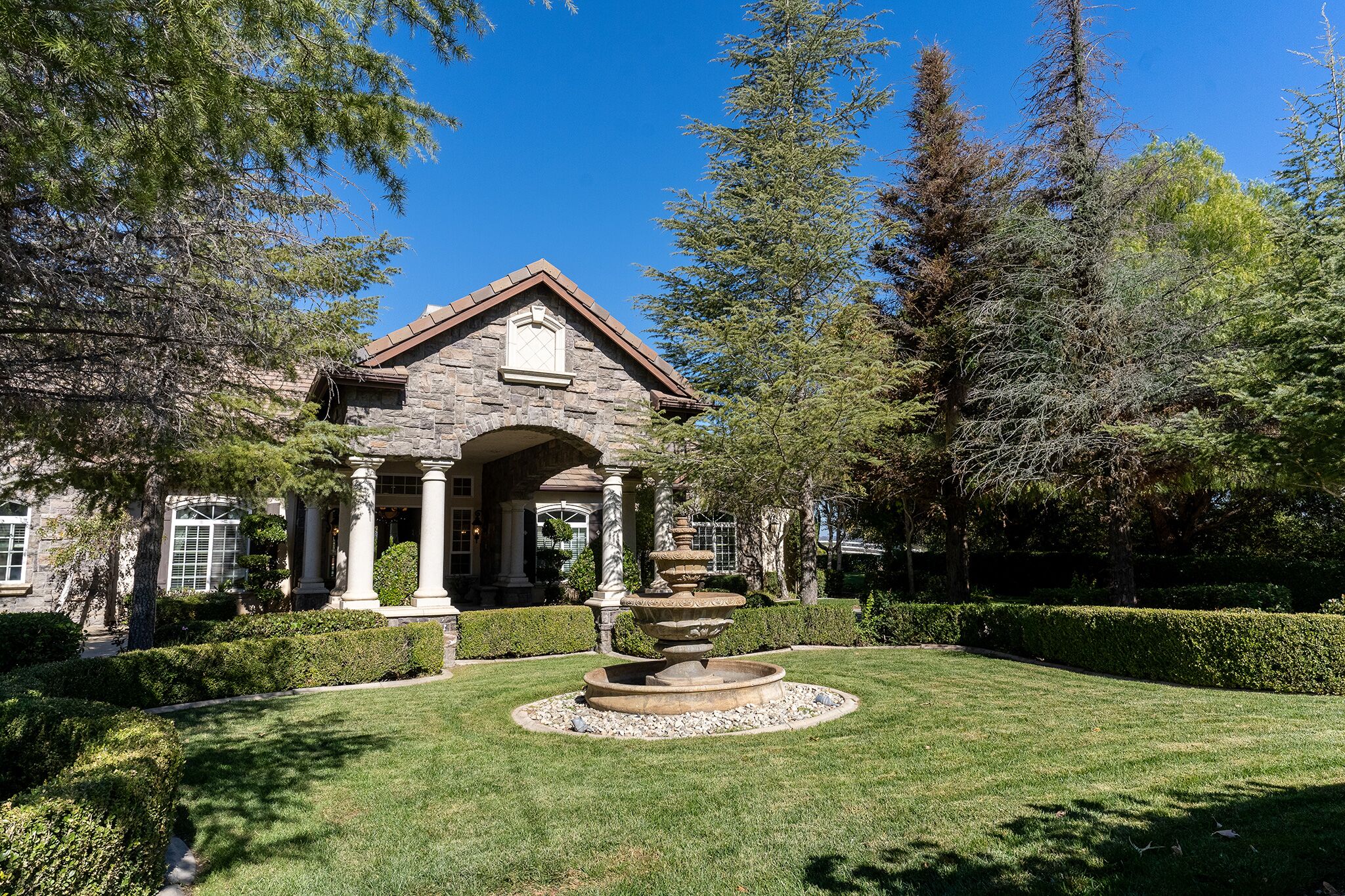 A welcoming and calm entrance to a modern treatment facility with natural landscaping. - Holistic Drug Rehab